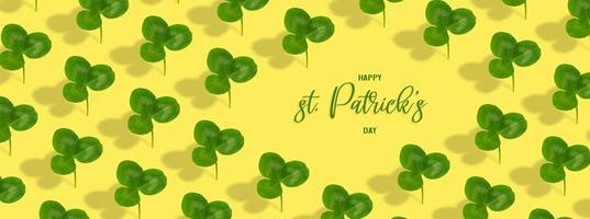 Happy St. Patrick's Day text with clover leaf pattern on colored background. Greeting banner photo