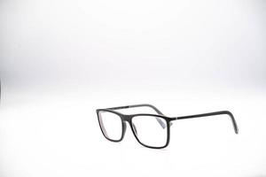 black glasses with a thick rim photographed against a white background, during a photo shoot in January 2023