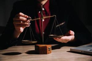 Justice and law concept.Male judge in a courtroom with the gavel, working with, computer and docking keyboard, eyeglasses, on table in morning light photo