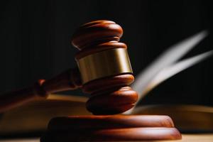 Justice and law concept.Male judge in a courtroom with the gavel, working with, computer and docking keyboard, eyeglasses, on table in morning light photo