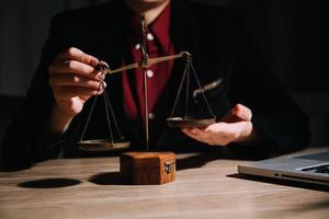 Justice and law concept.Male judge in a courtroom with the gavel, working with, computer and docking keyboard, eyeglasses, on table in morning light photo