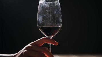 Set of hands holding red wine glass isolated on black background. photo