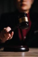 Justice and law concept.Male judge in a courtroom with the gavel, working with, computer and docking keyboard, eyeglasses, on table in morning light photo