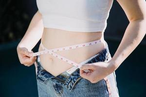 fat woman, fat belly, chubby, obese woman hand holding excessive belly fat with measure tape, woman diet lifestyle concept photo