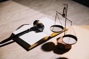 Justice and law concept.Male judge in a courtroom with the gavel, working with, computer and docking keyboard, eyeglasses, on table in morning light photo