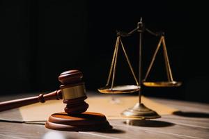 Justice and law concept.Male judge in a courtroom with the gavel, working with, computer and docking keyboard, eyeglasses, on table in morning light photo