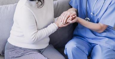 Homecare nursing service and elderly people cardiology healthcare. Close up of young hispanic female doctor nurse check mature caucasian man patient heartbeat using stethoscope during visit photo