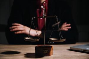 Justice and law concept.Male judge in a courtroom with the gavel, working with, computer and docking keyboard, eyeglasses, on table in morning light photo