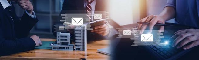 Businessman hands using Laptop typing on keyboard and surfing the internet on office table with email icon, email marketing concept, send e-mail or newsletter, online working internet network. photo