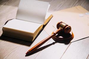 Justice and law concept.Male judge in a courtroom with the gavel, working with, computer and docking keyboard, eyeglasses, on table in morning light photo