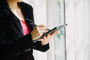 Mature businessman using a digital tablet to discuss information with a younger colleague in a modern business lounge photo