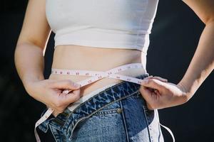 fat woman, fat belly, chubby, obese woman hand holding excessive belly fat with measure tape, woman diet lifestyle concept photo