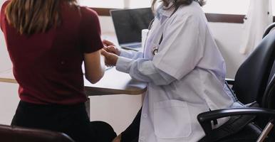 Homecare nursing service and elderly people cardiology healthcare. Close up of young hispanic female doctor nurse check mature caucasian man patient heartbeat using stethoscope during visit photo