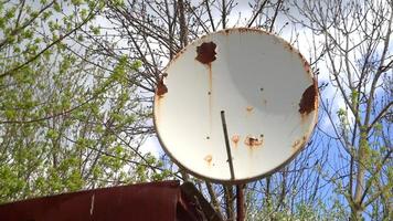 Large rusty satellite dish on the roof of the house. video