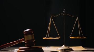 Justice and law concept.Male judge in a courtroom with the gavel, working with, computer and docking keyboard, eyeglasses, on table in morning light photo