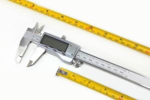 Construction roulette and digital vernier caliper micrometer construction tools on white background photo