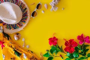 Beach accessories For the traveler on the yellow background - sunglasses, Straw hat, Shell and hibiscus flowers. Beach tourism concept. summer photo