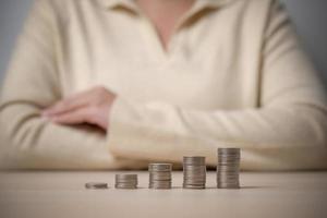 mujer trabajadora y un frasco lleno de monedas tailandesas. concepto de trabajar duro ahorrando más. foto