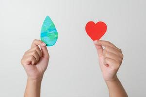 Woman hands holding paper colored earth element to empowered saving the world concept. Love and care to the earth. photo
