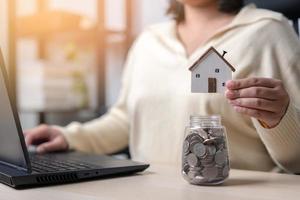 mujer trabajadora ahorra dinero para una nueva casa. concepto de ahorrar dinero para un nuevo edificio residencial. trabaje duro, ahorre más para una nueva vivienda. foto