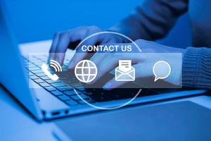 Contact us. people hand using laptop computer with virtual graphic icon diagram on desk at home office, digital marketing, work from home, business finance, internet network technology concept