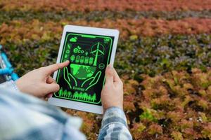 agronomist farmer hand using mobile tablet computer analysis data development in hydroponic greenhouse garden nursery farm, smart farming, digital technology and agricultural innovation concept photo