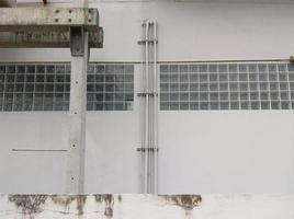 The white pipe rows along the concrete wall to drain the water. photo