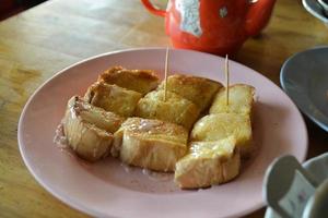 Toast in a pink plate put on the wood table. photo