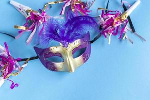 mascarilla festiva para la celebración del carnaval sobre fondo azul. fondo de carnaval mardi gras con máscaras de carnaval. concepto de carnaval plano. foto