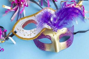 Festive face mask for carnival celebration on blue background. Mardi gras carnival background with carnival masks. photo