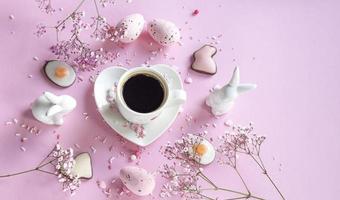 café fragante. café para pascua sobre un fondo rosa, conejitos y flores. huevos de Pascua. café. copie el espacio foto