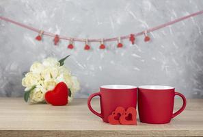 Valentine's Day. Valentine background. Two red cups and a heart. In the background is a bouquet of roses. Banner. copy space photo