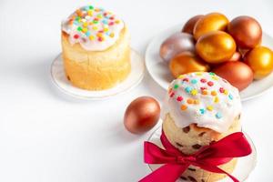 Easter cake with sweet icing and golden eggs on white plate. photo