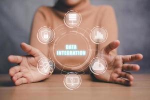 concepto de integración de datos, mano de persona que sostiene el icono de integración de datos en la pantalla virtual. foto
