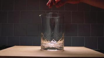 Adding Sugar Cubes and Bitters to a Mixing Glass video