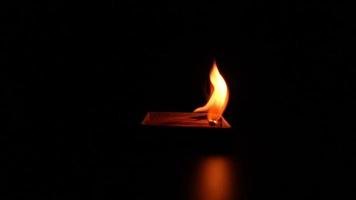 Flammenzungen aus brennender Streichholzschachtel auf schwarzem Hintergrund. Feuer super Zeitlupe. video