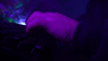 Male Hands Typing on a Computer Keyboard in Neon Lighting. Unrecognizable Guy Working on a Laptop at Night. Concept of Hackers and Cyber Crimes or Cyberspace. video