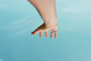 mano arriba gesticulando en el cielo azul, sentimientos y emociones foto