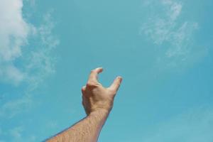 hand up gesturing in the blue sky, feelings and emotions photo