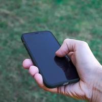 mano sosteniendo un teléfono inteligente, adicción móvil foto