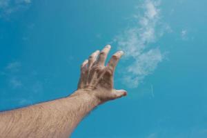 hand up gesturing in the blue sky, feelings and emotions photo