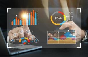 Business man wearing suit working on laptop and smartphone mobile phone to smart digital marketing on virtual screen, Analyzes the working with digital reality graphics. Business technology concept. photo
