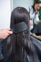 peluquero profesional lavando el cabello de una mujer joven en un salón de belleza. primer plano del cabello de la mujer en el salón de belleza, concepto de peinado foto