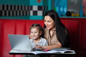 Mother helping her daughter with homework. Mother helping her daughter with homework. Happy childhood photo