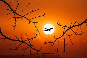 Vacation travel concept. Silhouette of a passenger plane flying in the sky photo