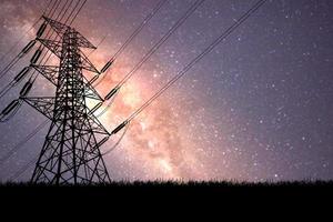 torres de alta tensión en la noche hay un telón de fondo de la vía láctea y las estrellas. foto