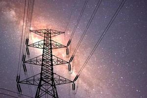 high voltage pylons at night There is a backdrop of the Milky Way and stars. photo