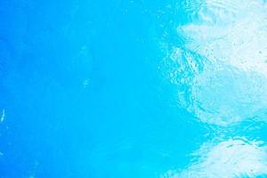 Blurred transparent blue colored clear calm water surface texture with splashes and bubbles. Trendy abstract nature background. Water waves in sunlight. water background photo