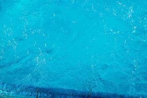 textura superficial de agua tranquila clara de color azul transparente borrosa con salpicaduras y burbujas. fondo de naturaleza abstracta de moda. ondas de agua a la luz del sol. fondo de agua foto