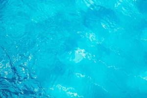 Blurred transparent blue colored clear calm water surface texture with splashes and bubbles. Trendy abstract nature background. Water waves in sunlight. water background photo